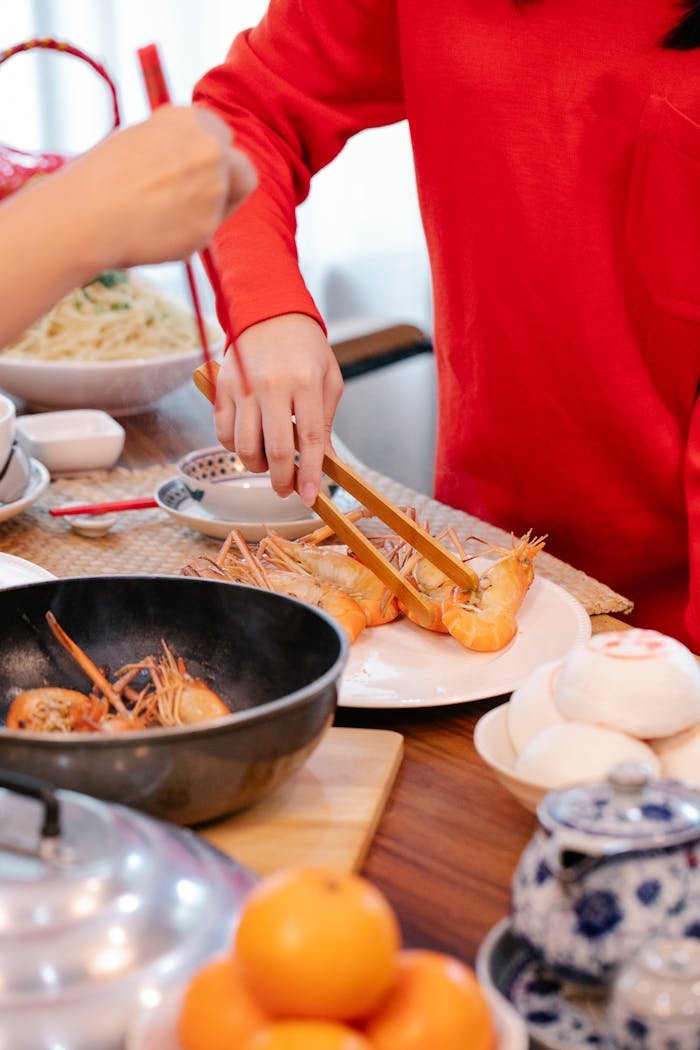 why-choose-us Hands preparing prawns in a lively Chinese kitchen setting. Perfect for culinary themes.
